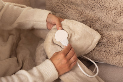 Aansluiten van de afneembare stekker op een elektrische warmtedeken van Serenova – eenvoudig in gebruik en veilig te wassen.