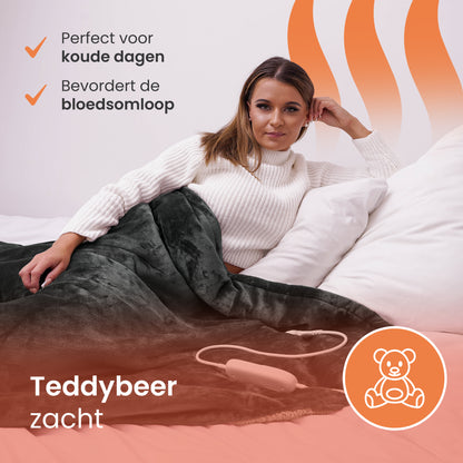 Vrouw onder elektrische warmtedeken met teddybeerzachte stof – ideaal voor koude dagen en betere bloedsomloop.